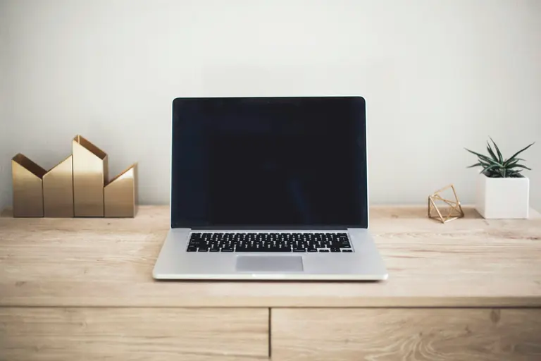 Laptop en accessoires klaar voor werk op een opgeruimd bureau
